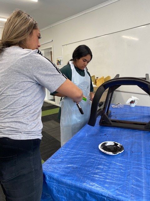 Tihei Rangatahi staff and rangatahi paint a chair as part of the zero-waste project. 