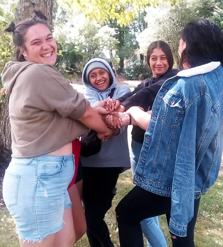 Some of the rangatahi whose truancy has been turned around by the wānanga smiling and holding hands