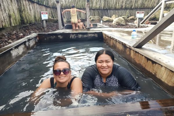 Two wāhine relaxing at Ngāwhā Springs hot pools, a facility steeped in kaupapa Māori 