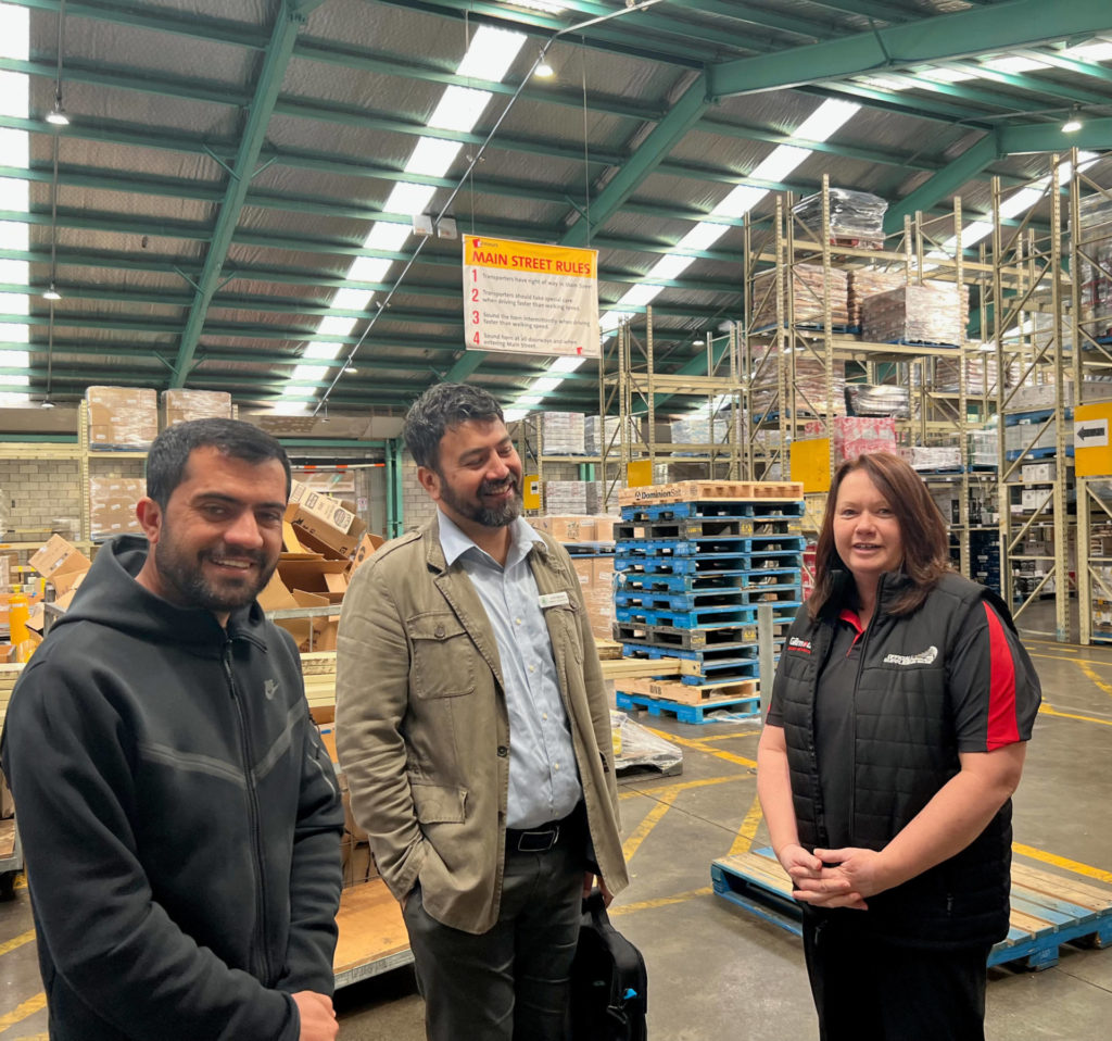 Akbar Hashimi with translator, Amin Bakhsh and Sam Gebser, Gilmours' HR Manager in a Gilmours' warehouse