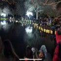 Cyclone affected whānau in Te Matau-a-Maui stand around water at night looking at the paper lanterns the made and floated in memory of their dead during Matariki 2023