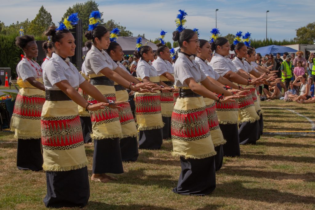 In this picture, taken at Marlborough Multicultural Festival 2025, which Margaret Western convened, young people perform wearing cultural dress of the Pacific Islands. They stand in three lines,