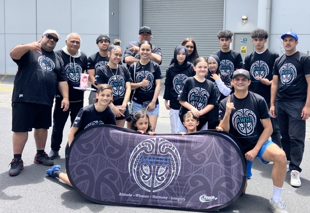 About 20 AWHI Influencers are pictured around a a black and blue AWHI banner. They are all wearing AWHI t shirts and vary in age from pre-teen to adult.