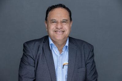 George Reedy, a member of Māori reference Group, smiles at the camera. He is dressed in a blue open necked shirt and dark jacket. 