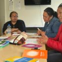 3 women are sitting around a table at a wananga