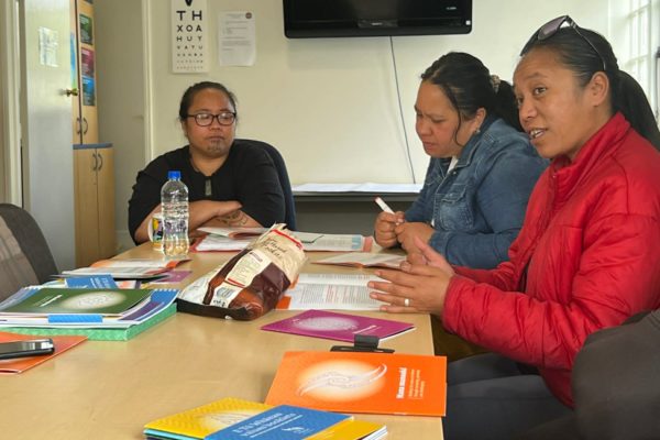 3 women are sitting around a table at a wananga