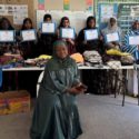 A group of women from migrant and former refugee communities are holding certificates for completion of a sewing course. One of the organisers, Fadumo Ahmed sits in the foreground.