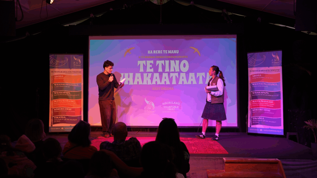 Tamati Moriarty and Paige Wilson from Hurō Productions on stage presenting as MCs for Ka Rere te Manu Awards 2026.