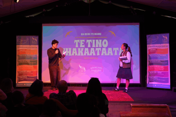 Tamati Moriarty and Paige Wilson from Hurō Productions on stage presenting as MCs for Ka Rere te Manu Awards 2026.
