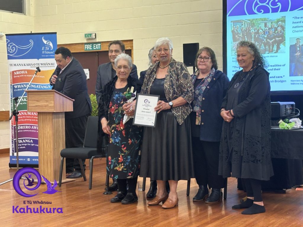 Lovey Edwards and Ngatiriti King of Nannies Against P are pictured holding their certificate recognising them as finalists in the Ann Dysart Kahukura Award 2026. With them are Brent Mio, Darrin Haimona, Heni Turner, E Tū Whānau Kaiwhakahaere, and Katie Murray.
