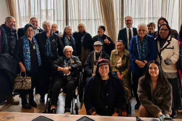 A group representing Nannies Against P are pictured. There are about 30 people pictured, some of whom are in wheelchairs. Everyone is dressed formally.