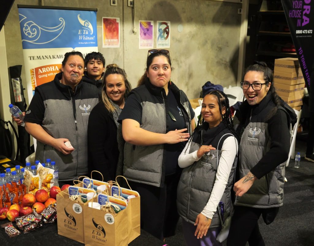 Candis Brunning is pictured with five other Te Hapori Ora kaimahi. They all wear grey clothing bearing the Te Hapori Ora logo.