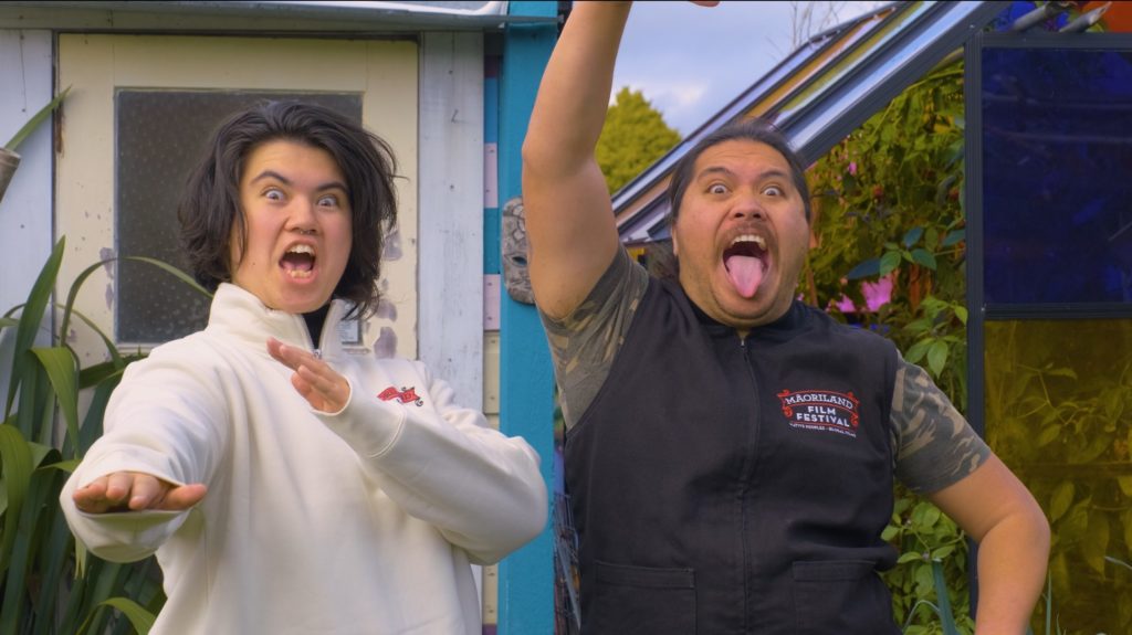 Two rangatahi, Waitahi Aniwaniwa McGee and Tahuaroa Ohia, doing the pūkana while wearing Maoriland shirts.