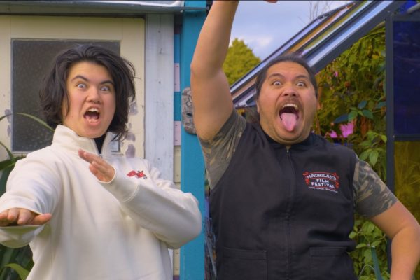 Two rangatahi, Waitahi Aniwaniwa McGee and Tahuaroa Ohia, doing the pūkana while wearing Maoriland shirts.
